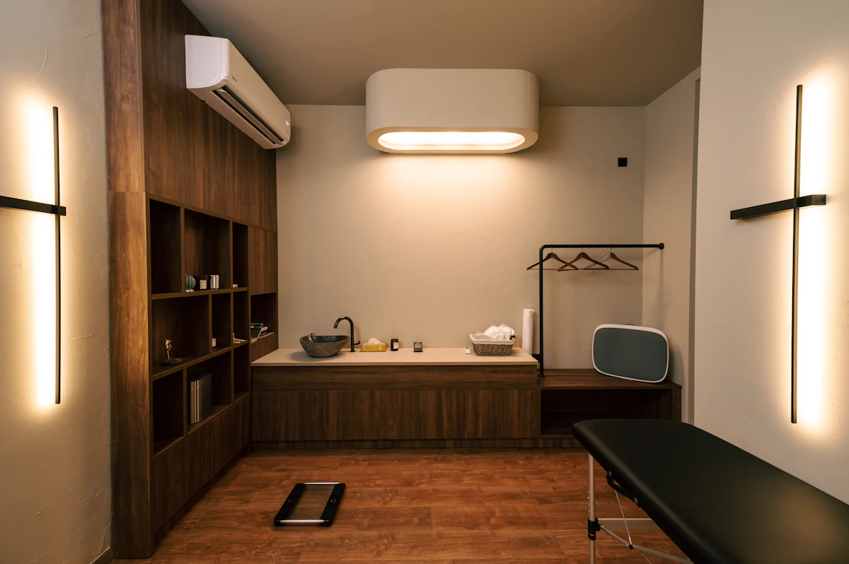 Sala de atendimento clara e organizada, com maca e luz suave